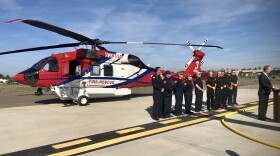 San Diego Mayor Kevin Faulconer and members of the San Diego Fire-Rescue Department stand in front of a new helicopter, Dec. 12, 2019.
