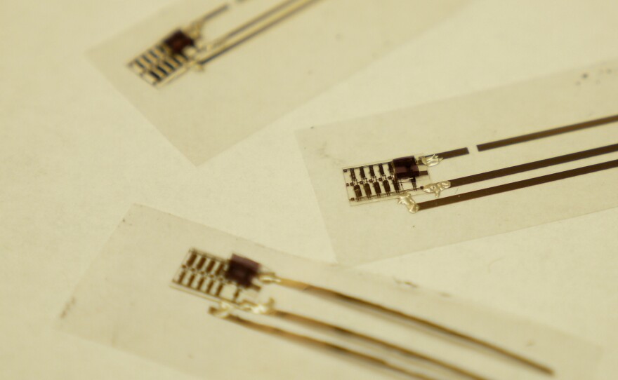 A pressure sensor is sandwiched inside layers of plastic. It senses the pressure unleashed on the plastic and changes its electrical properties.