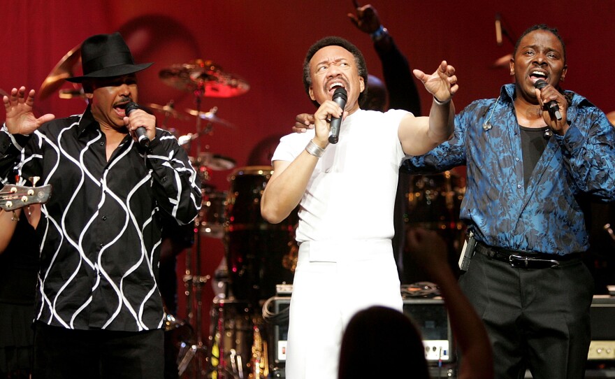 Maurice White flanked by singers Ralph Johnson (left) and Philip Bailey (right) of the band Earth, Wind & Fire perform at the Wiltern Theater December 11, 2004 in Los Angeles.