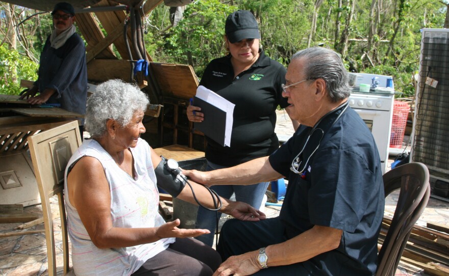 Dr. Eduardo Ibarra checks the blood pressure of Carmen Garcia Lavoy in the Toa Baja area of Puerto Rico. He's been making house calls in the area with nurse Erika Rodriguez.