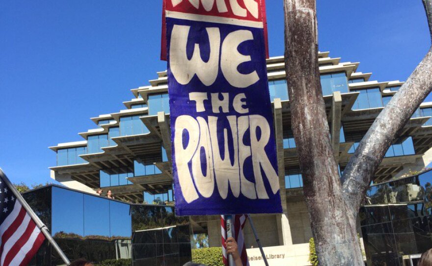 UCSD students protesting President Trump's immigration ban march with signs, Monday, Jan. 30, 2017.