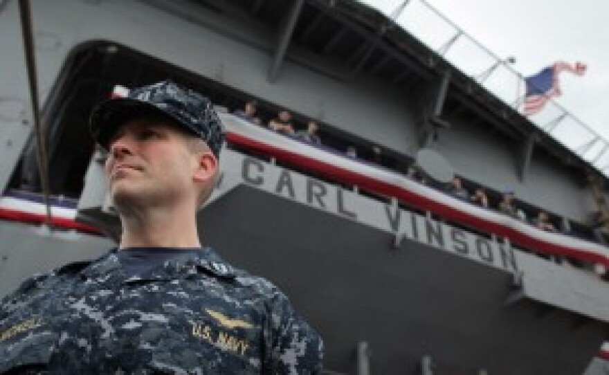 A sailor looks out from a deck of the USS Carl Vinson
