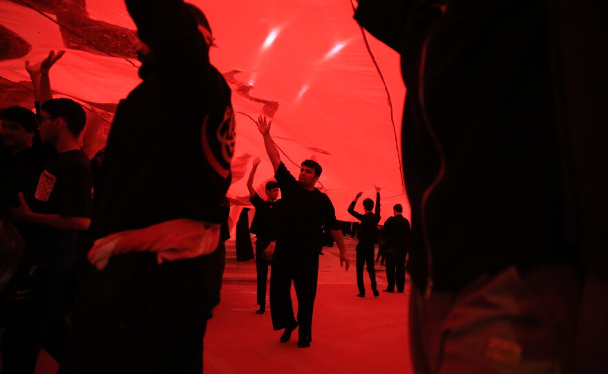 Pilgrims hold a large piece of fabric above their heads while taking part in mourning rituals inside the Imam Hussein Shrine in Karbala during the Arbaeen commemoration.
