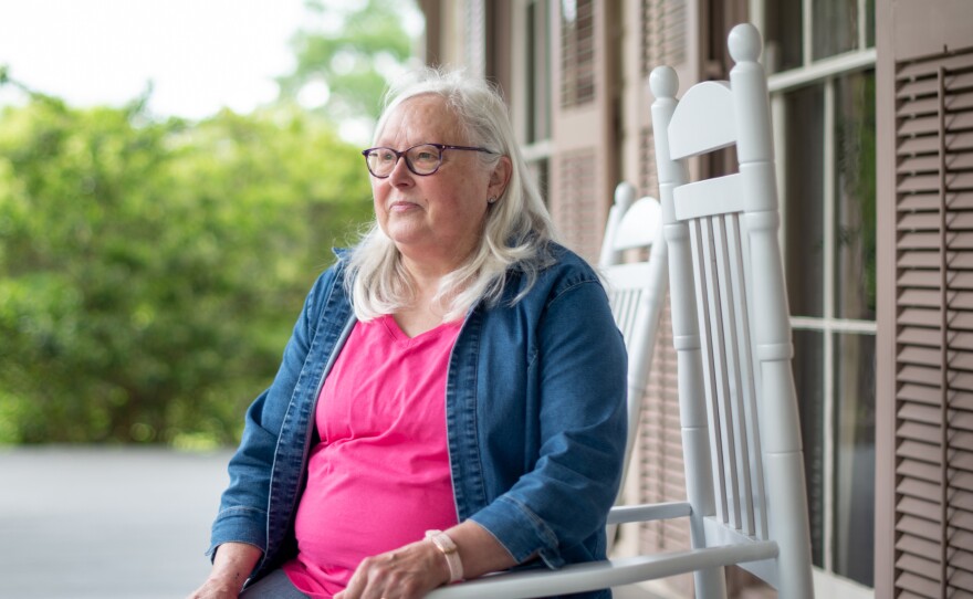 Susan Campbell, a local historian, sits on the front porch of Fendall Hall. She says she'd like to see more information about the Young-Dent family included on the historical marker at the mansion.