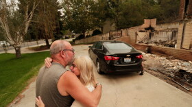 Allen Sather and his wife Kimberley embrace at the duplex they rent on W. Indian Trail Rd. after it burned in a wildfire in Spokane, Wash., Sunday, Aug. 2, 2026.