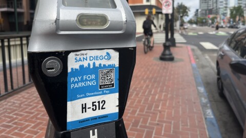 A man rides past a City of San Diego parking meter, Aug. 15, 2025.