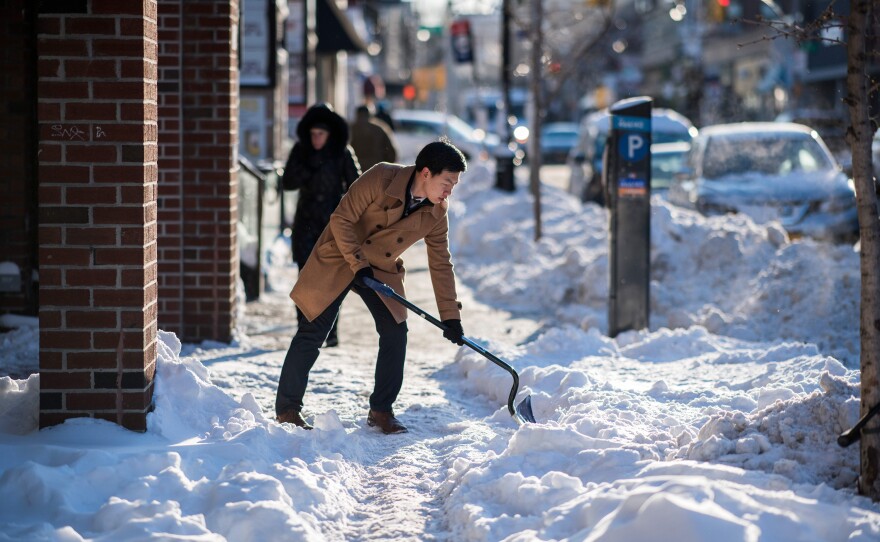 A man shovels snow from a footpath in New York on Friday. The National Weather Service said early Friday that very cold temperatures and wind chills will follow for much of the Northeast through the weekend.