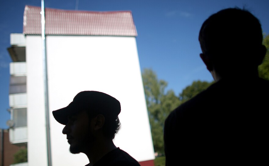 Syrian refugees look out of the windows of the Pentagon apartments, where they are temporally being housed in New Hardenberg, Germany.