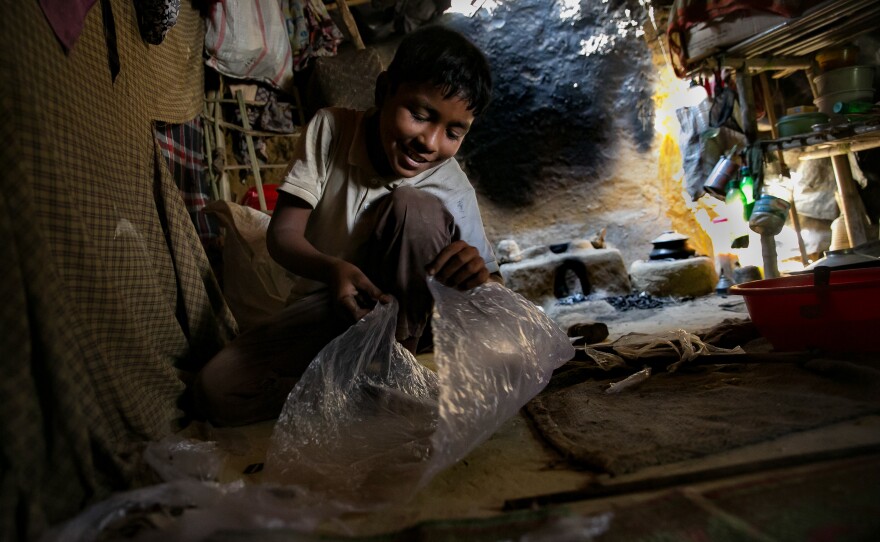 Ten-year-old Khamal makes a kite in his shelter in the camp. He gives the kites away to other kids.