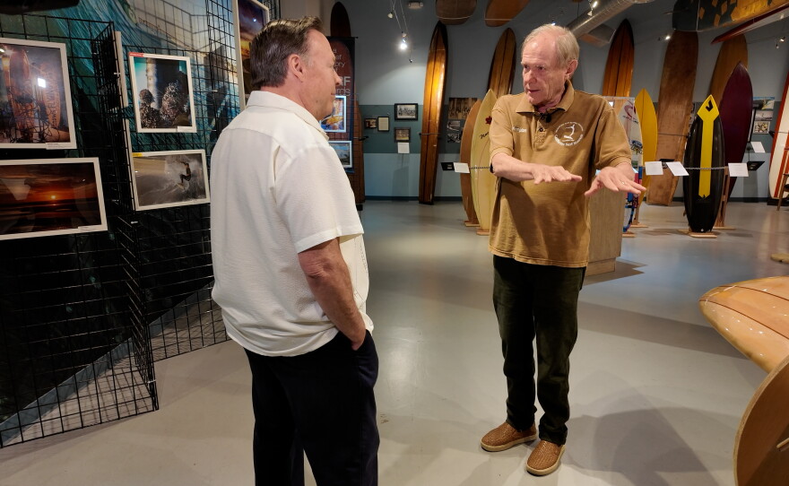 California Surf Museum Executive Director Jim Kempton is shown being interviewed by KPBS reporter John Carroll at the Oceanside museum on July 1, 2026.