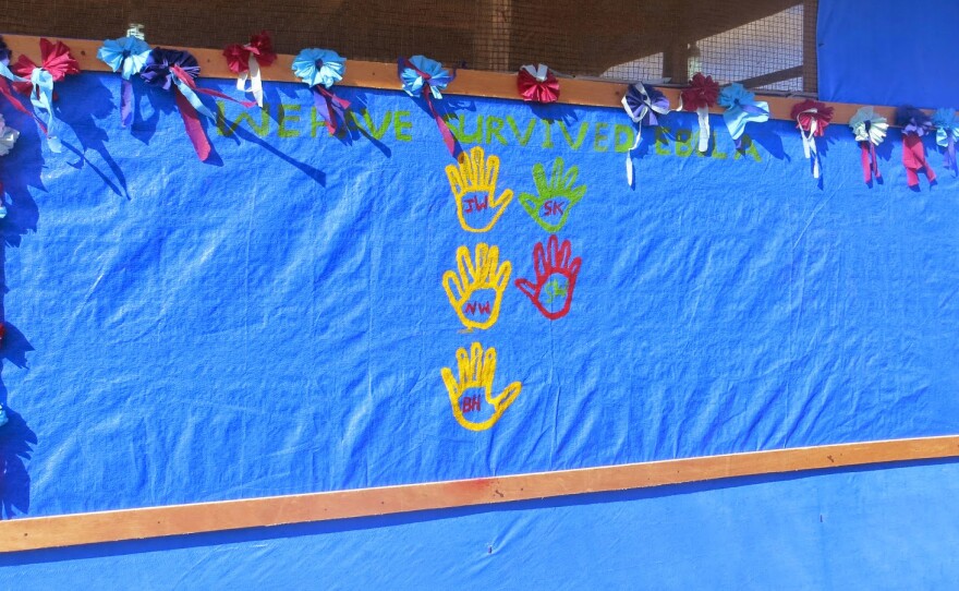 A survival wall is set up at the treatment center with the patients painting their hands and writing their initials on them as they leave. A small triumph.