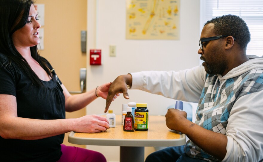 Occupational therapist Lydia Bongiorni works with Troy Hodge on grasping and lifting objects at a rehabilitation center in Gwynn Oak, Md. "You basically have to start over again," Hodge says. "You retrain your brain to use your limbs."