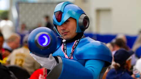 A cosplayer dressed as Mega Man during Comic-Con poses with his weapon, July 23, 2026.