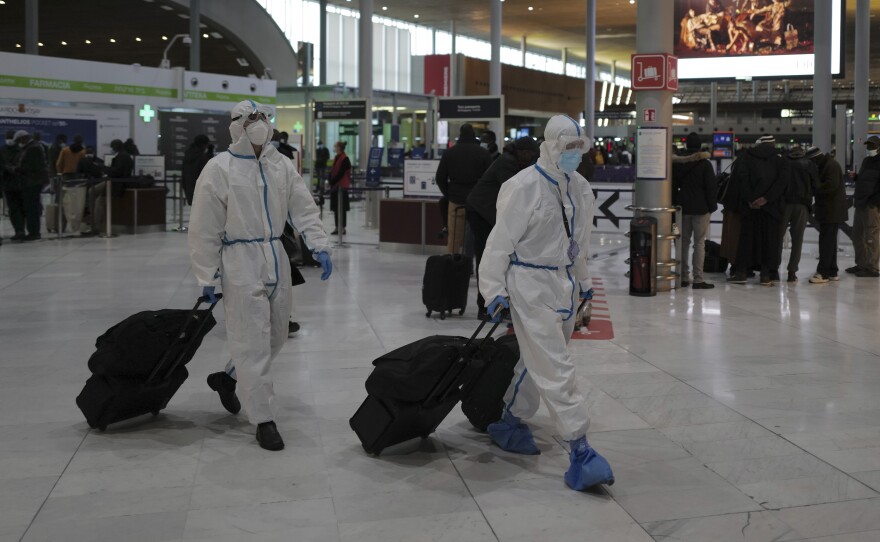The U.S. has updated its travel advisory list with more than 115 new warnings, as countries in Europe, Asia, South America and elsewhere see new waves of infection. Here, passengers from Taiwan wear protective gear as they arrive at France's Charles de Gaulle Airport north of Paris earlier this year.