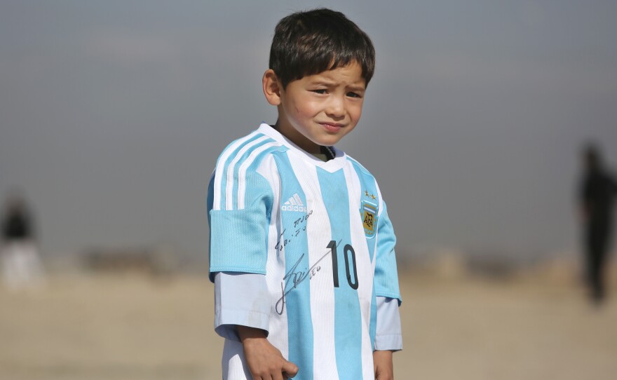 Five-year-old Murtaza Ahmadi, an avid Lionel Messi fan from Afghanistan, poses in a signed jersey from the Argentinian soccer great on Feb. 26. The boy's father says the media coverage led to threats toward the family.