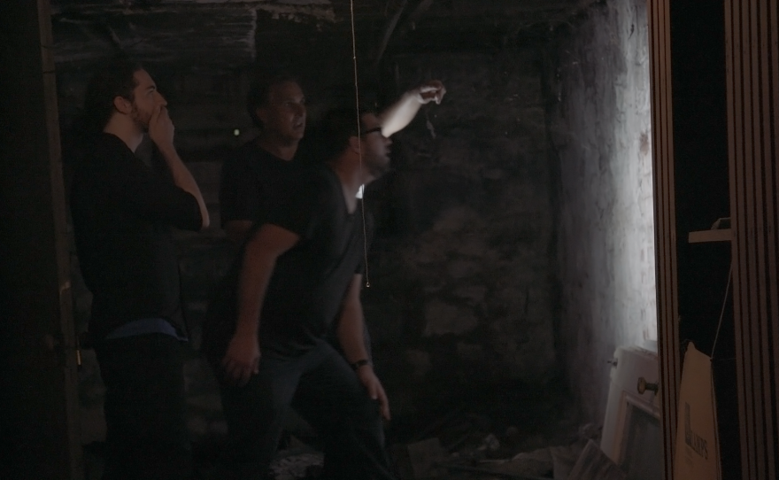 Travis Basso, Ryan Fazekas and Steve Zazulyk find the bricked up doorway to a hidden tunnel.