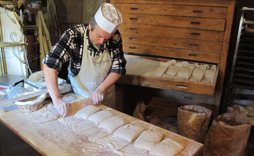 Roland Feuillas of Cucugnan, France is "among a small movement paysannes boulangers (peasant bakers) who grow their own organic wheat, mill it into flour and make their bread," Fromartz writes. Here, Feuillas shapes loaves with a single cut.