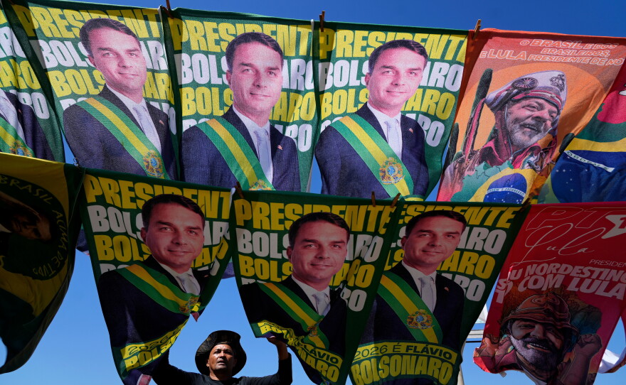 A street vendor sells campaign flags of presidential candidates Sen. Flavio Bolsonaro and current President Luiz Inacio Lula da Silva who is running for reelection in Brasilia, Brazil, Tuesday, Sept. 29, 2026.