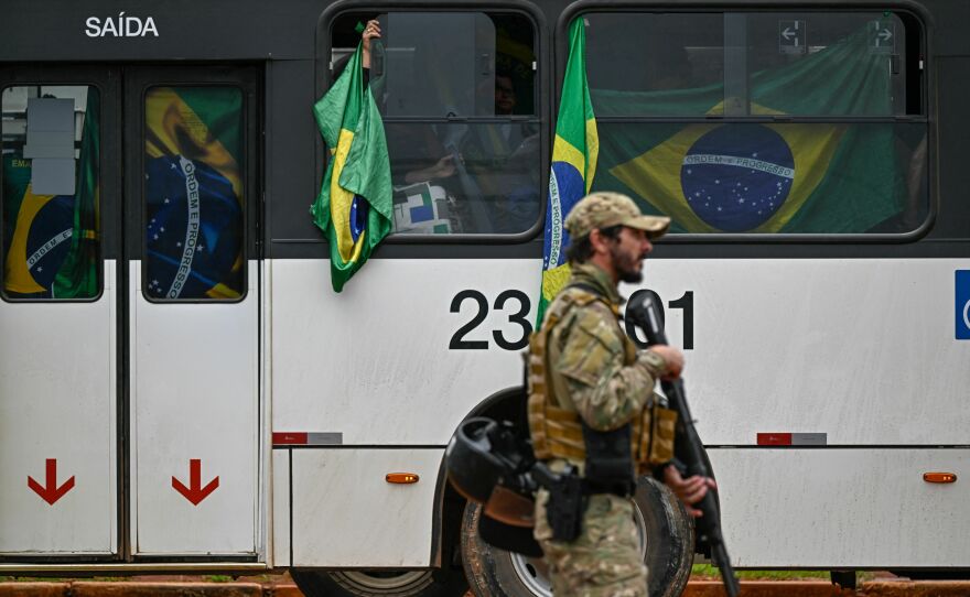 Supporters of Brazil's far-right ex-president, Jair Bolsonaro, are taken in police custody in buses to the federal police headquarters on Monday.