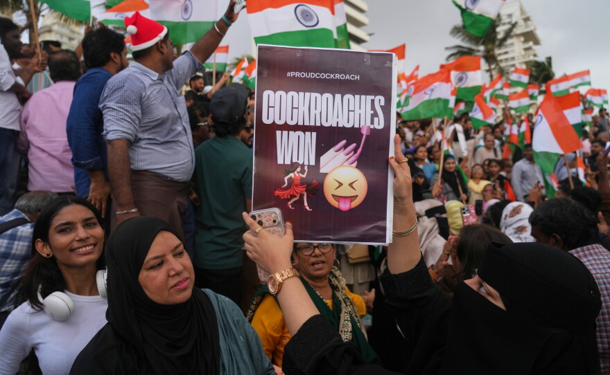 A protester holds a placard after India's Education Minister Dharmendra Pradhan resigned following nationwide protests as part of the Cockroach Janta Party's protest movement in Mumbai, India on Saturday.