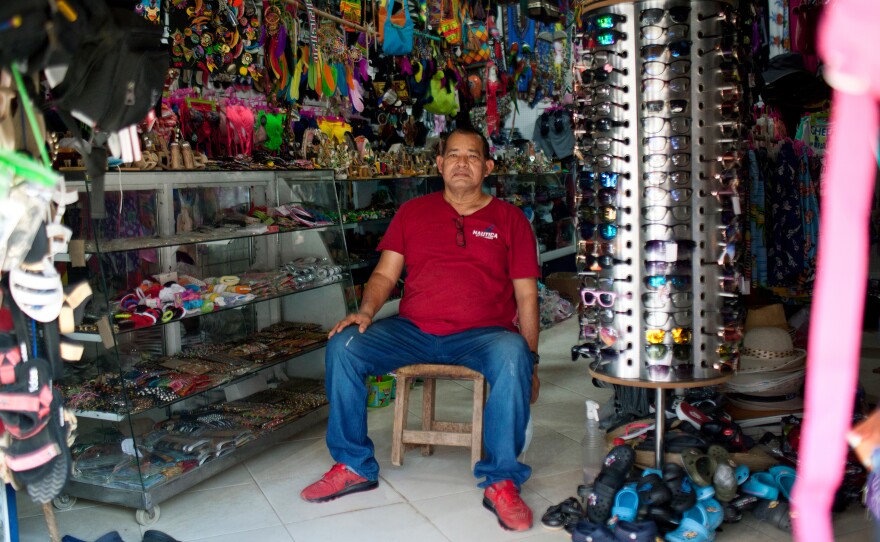 Jairo Soto, 60, at his souvenir store in Necoclí. Soto says that he now does a brisk business selling machetes, rubber boots, jeans and T-shirts to the migrants.