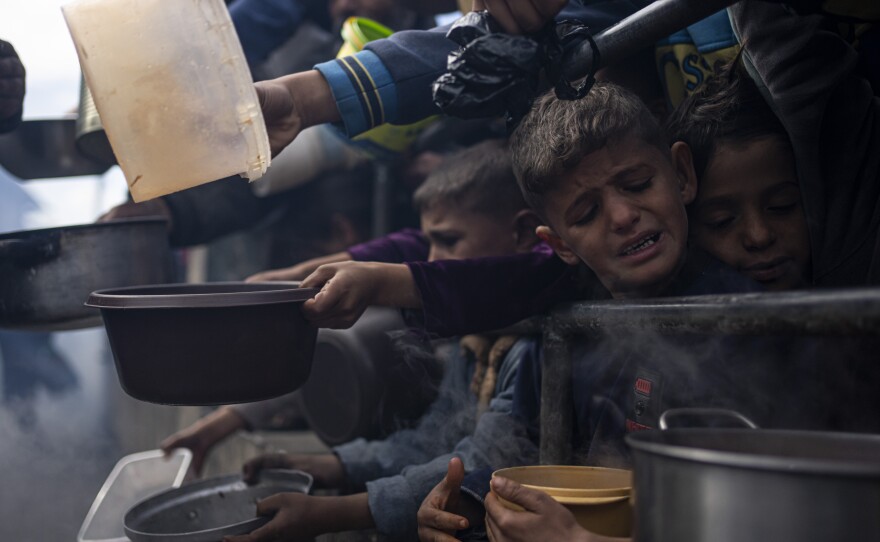Palestinians line up for a free meal in Rafah, Gaza Strip, Friday, Feb. 16, 2024.