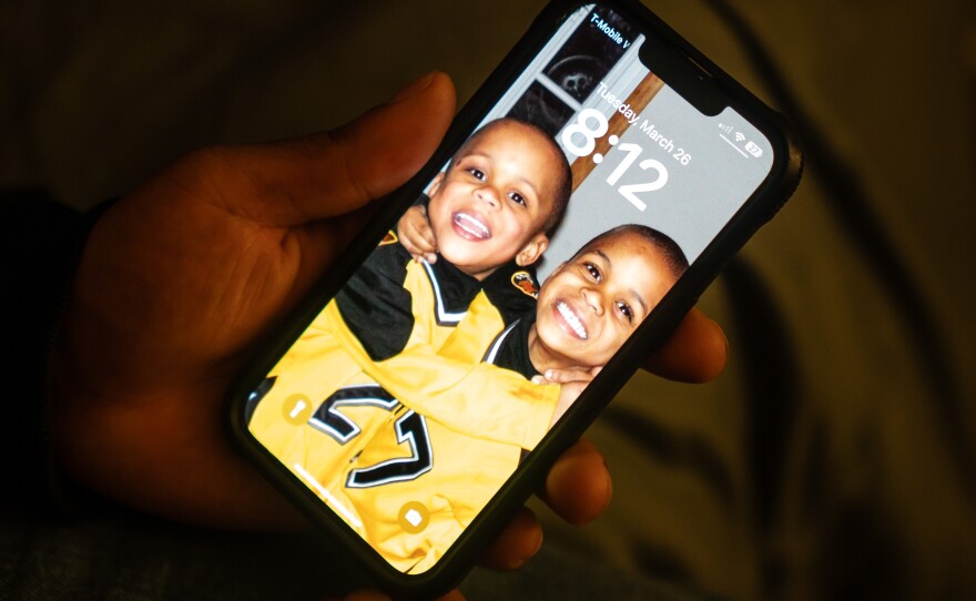 Zion Kelly keeps a screensaver on his phone of he and his brother as young kids.