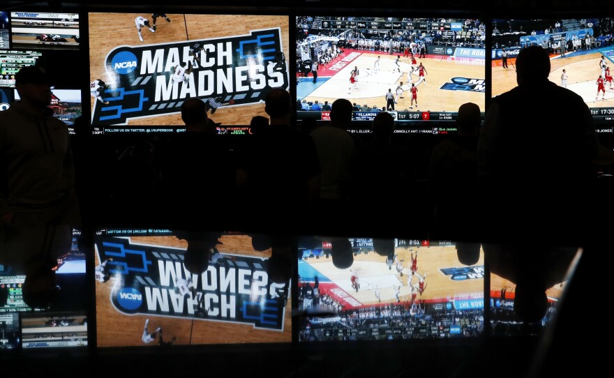 People watch coverage of the first round of the NCAA college basketball tournament at the Westgate Superbook sports book on March 15, 2018, in Las Vegas.