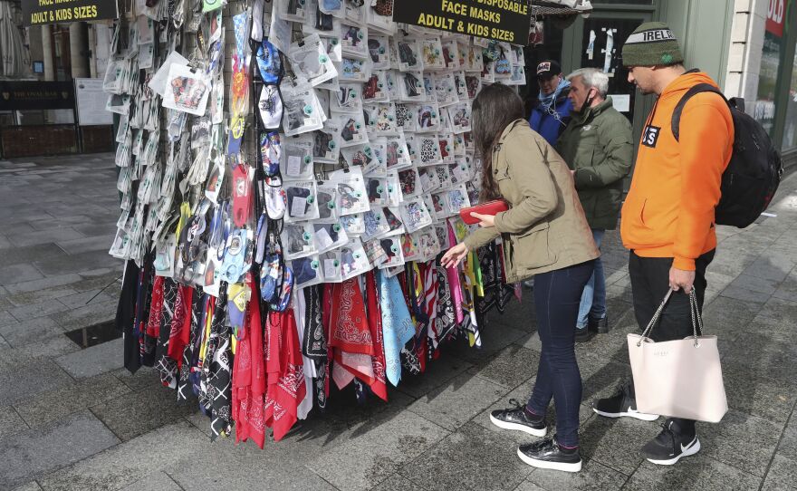 Shoppers buy face masks on O'Connell Street in Dublin city centre on Tuesday. Ireland's government is putting the country at its highest level of coronavirus restrictions for six weeks in a bid to combat a rise in infections.