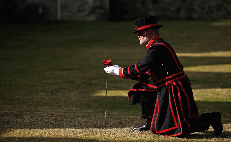 Crawford Butler, the longest serving Yeoman Warden at the Tower of London, plants the first ceramic poppy in the dry moat at Tower of London on July 17.