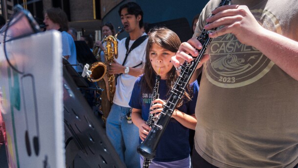 Protesters opposed to San Diego Mayor Todd Gloria's budget cuts to arts programs gather at San Diego's Civic Center Plaza before a City Council meeting on April 20, 2026.