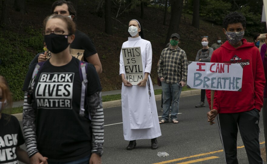 In Washington, D.C., on Tuesday, Sister Quincy Howard protests the arrival of President Trump to the Saint John Paul II National Shrine in Washington.