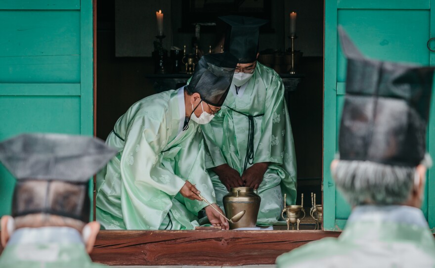 Men pour a drink during the spring ceremony at Museong Seowon.