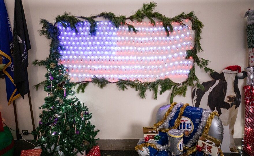 Republican Rep. Mike Gallagher, of Wisconsin has a display featuring an American flag out of twinkle lights, an inflatable Miller Lite chair and a cutout of a cow wearing a Santa hat.