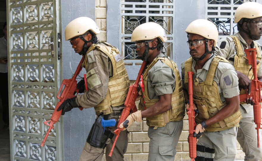 Helmeted Chadian and other African police commandos, armed with dummy rifles hunt down terrorist suspects who've taken hostages in the building, during a US military led Flintlock 2017 law enforcement exercise in Ndjamena Chad, 15 March 2017.
