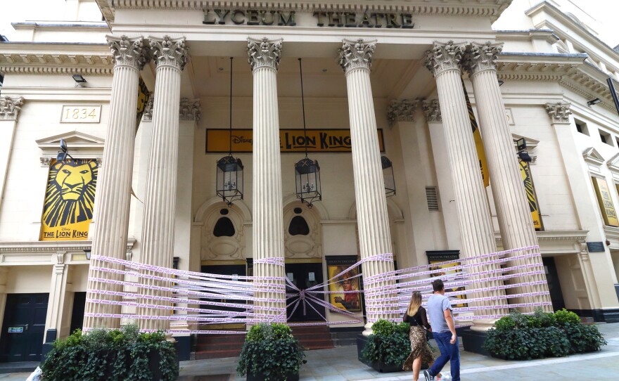 London's Lyceum Theatre is wrapped in pink tape bearing the words "Missing Live Theatre," part of a campaign by a group of British stage designers.