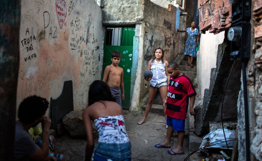 Lala, center, and Milena, back to camera, play a pick-up game of soccer in their neighborhood the Rocinha favela, or shanty town in Rio de Janeiro.