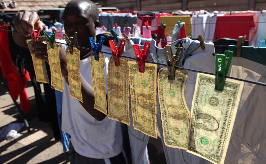 Alex Mupondi, hangs one dollar notes on a drying line after washing them in Harare, Zimbabwe, in 2010, shortly after Zimbabweans began trading in the American currency after the Zimbabwean dollar went into a hyperinflationary spiral.