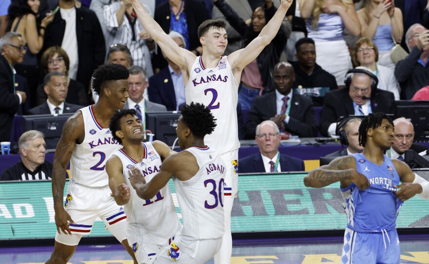 K.J. Adams #24, Remy Martin #11, Ochai Agbaji #30, and Christian Braun #2 of the Kansas Jayhawks celebrate after defeating the North Carolina Tar Heels 72-69 during the 2022 NCAA Men's Basketball Tournament National Championship in New Orleans.