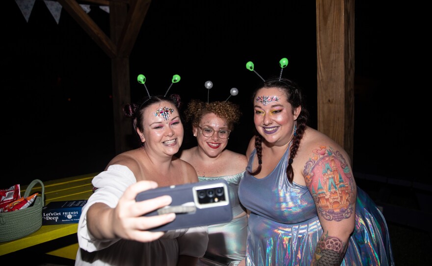 Friends Mary Yale, 31, Alleiah Keeley, 33, and Regina Sigafoos, 30, take a selfie during Camp Roundup's space-disco party.