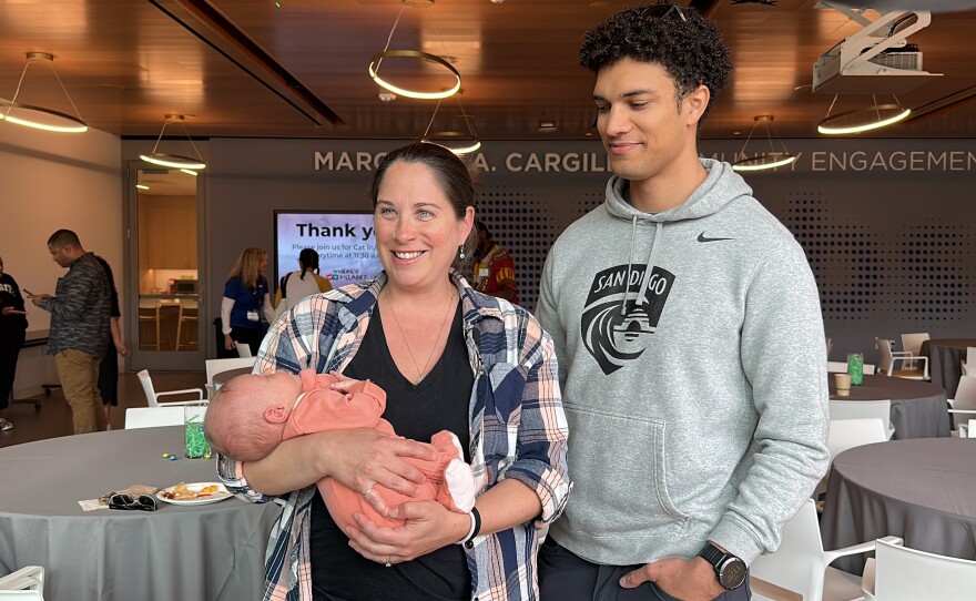 Rebecca and Dominic Carnahan hold their baby at the KPBS Find your Village resource fair. March 23, 2024. 