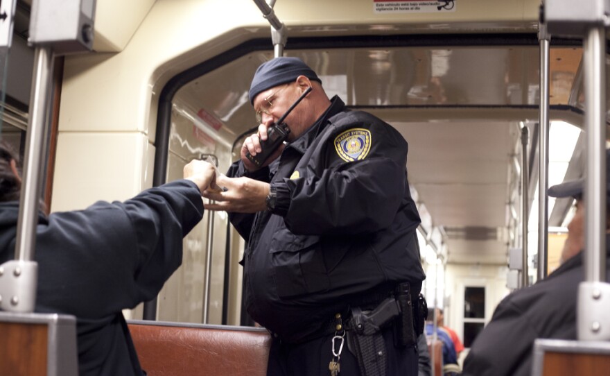 Trolley cop Jeff Metz asks a passenger for her ticket.