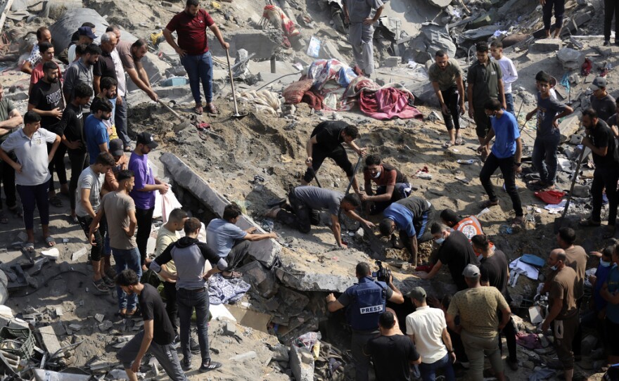 FILE - Palestinians work among debris of buildings that were targeted by Israeli airstrikes in Jabaliya refugee camp, northern Gaza Strip, Wednesday, Nov. 1, 2023. The United Nations Human Rights office says it's concerned the number of deaths and scale of destruction from an Israeli air strike on a Gaza Strip refugee camp could amount to war crimes. But experts say it could be tricky to prove strikes on the Jabaliya camp on Oct. 31 violated international law.