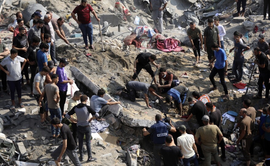 FILE - Palestinians work among debris of buildings that were targeted by Israeli airstrikes in Jabaliya refugee camp, northern Gaza Strip, Wednesday, Nov. 1, 2023. The United Nations Human Rights office says it's concerned the number of deaths and scale of destruction from an Israeli air strike on a Gaza Strip refugee camp could amount to war crimes. But experts say it could be tricky to prove strikes on the Jabaliya camp on Oct. 31 violated international law. 