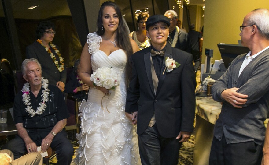 Saralyn Morales, center left, and Isajah Morales walk down the aisle at the Sheraton Waikiki in Honolulu shortly after Hawaii's new gay marriage law took effect Monday.