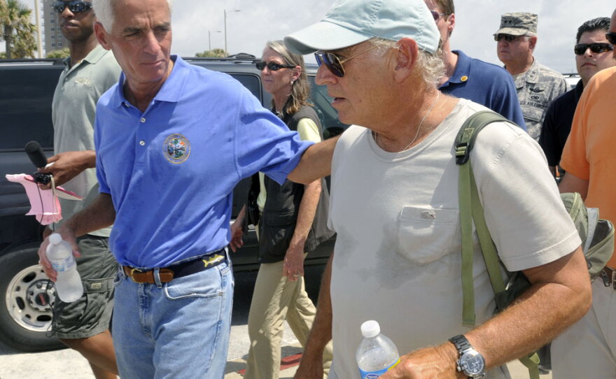Florida Gov. Charlie Crist (left) and entertainer Jimmy Buffett walk along Pensacola Beach, where Buffett plans to open a new hotel.