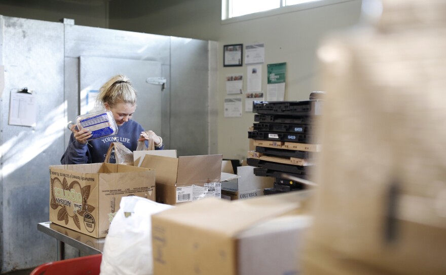 Volunteer Ella Cagle of Wake Forest loads bags with frozen meat. The food bank serves individuals and families in need with a week's worth of groceries.