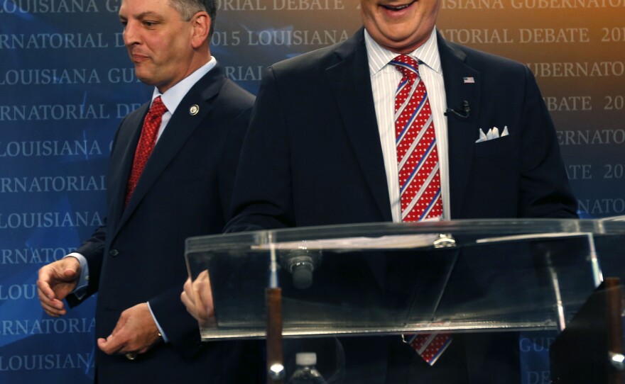 Democratic state Rep. John Bel Edwards, left, walks past U.S. Sen. David Vitter, R-La., as they take their places before a debate.