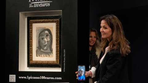 Peri Cochin, right, founder of "1 Picasso for 100 euros," speaks on the phone with the winner, Ari Hodara of Paris, next to the painting 'Head of a Woman' by Pablo Picasso, painted in 1941, after the raffle draw at Christie's in Paris, Tuesday, April 14, 2026, in support of Alzheimer's research.