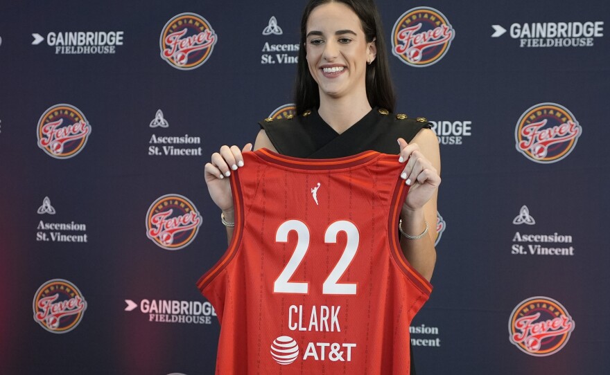 Clark holds up her Fever jersey after a Wednesday press conference in Indianapolis.